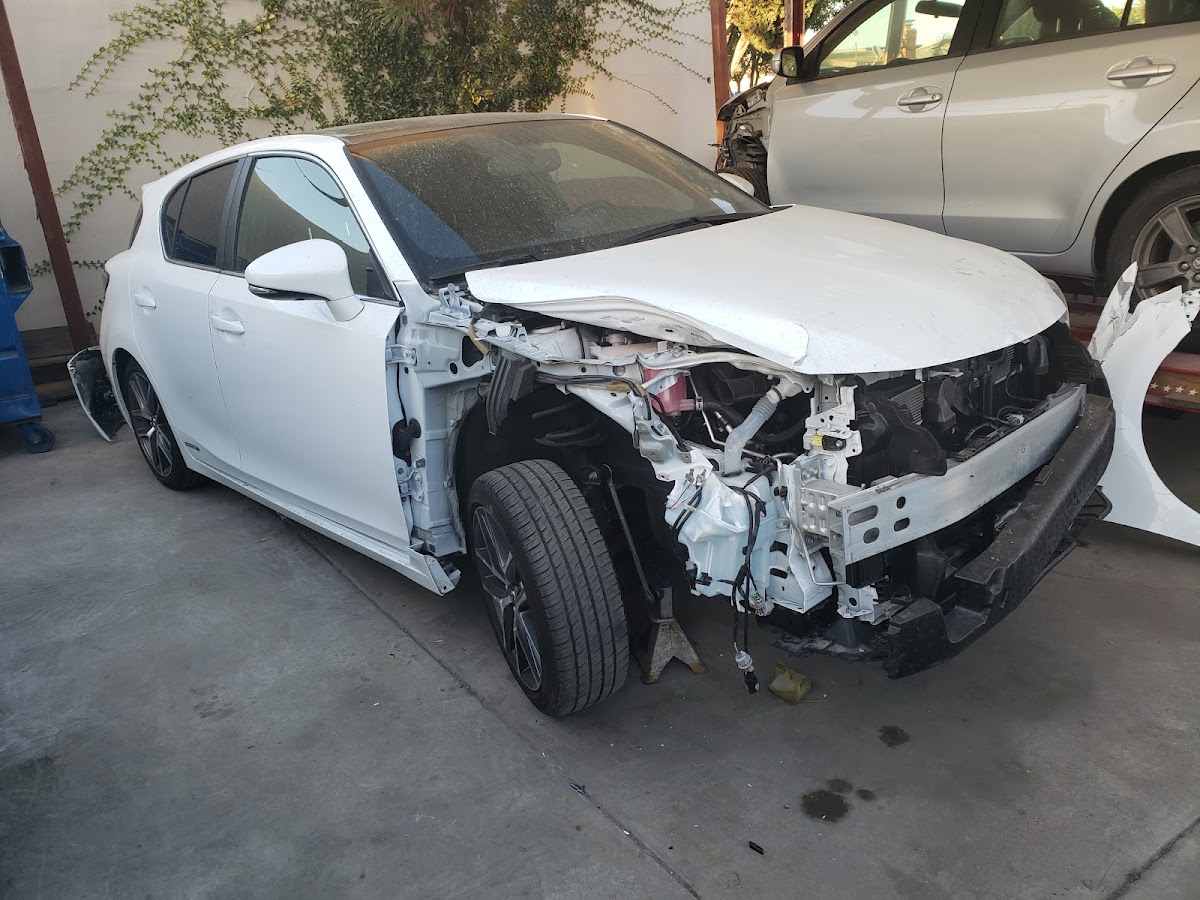 White Lexus with front-end collision damage in for repair