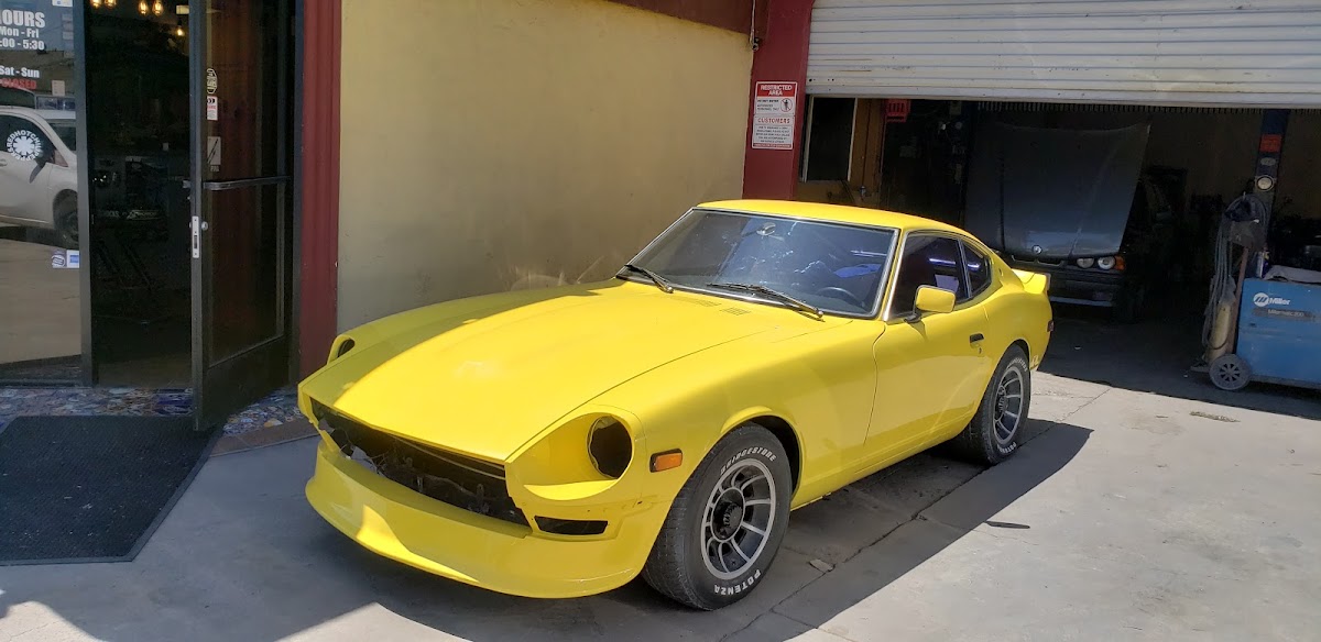 Yellow classic Datsun parked at the shop